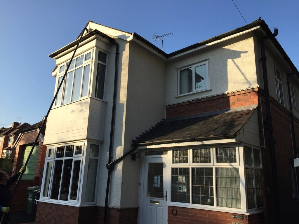 Semi-detached house with freshly cleaned bay windows in bright sunshine
